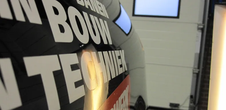 Bedrijfsbus van DIT Bouw en Techniek onder de lamp